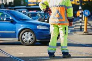 Verkeersregelaar aan het werk met seinpalen op straat - voordelen van verkeersregelaar worden duidelijk gemaakt
