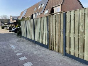 Schutting met poort in een tuin, demonstreert de voordelen van toegankelijkheid, veiligheid en esthetische waarde voor je bui