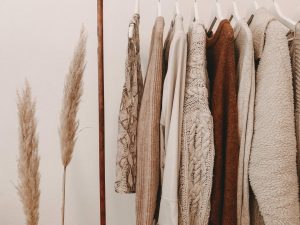 Model draagt dameskleding trends voor herfst en winter met gebreide trui en aardetinten